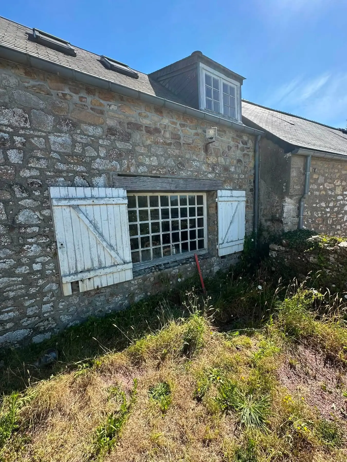 Ancienne baie d'atelier à petits carreaux sous linteau bois dans un mur en pierre, avant travaux - LAMY Maçonnerie