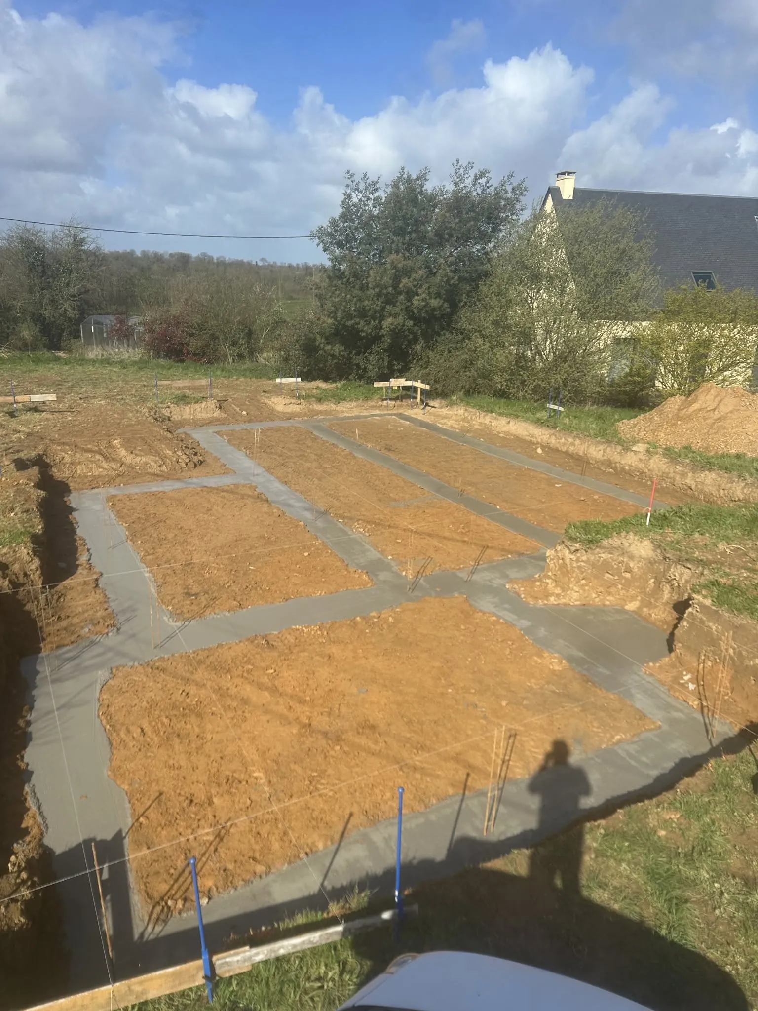 Semelles filantes en béton coulées pour une maison neuve, terrain terrassé et ferraillage en attente